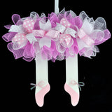 Wooden wreath with skirt at the top made from mesh, with ballerina legs and shoes hanging from the bottom