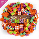 Orange burlap wreath with bright colorful ribbons surrounding the Hello Summer wooden sign