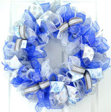 Winter wreath with royal blue, white and silver mesh on a white front door